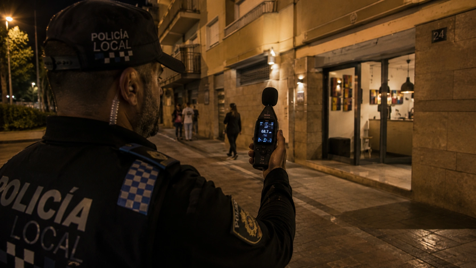 Patrulla de policía local utilizando un sonómetro para la medición de ruidos y control de convivencia urbana